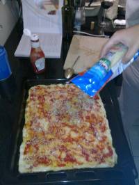 On badigeonne la pâte avec le ketchup, on place le fromage râpé On badigeonne la pâte avec le ketchup, on place le fromage râpé