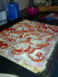 On complète la pizza avec les rondelles de tomate, les dés de poivrons et l'origan On complète la pizza avec les rondelles de tomate, les dés de poivrons et l'origan